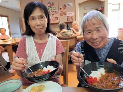 受けとられた事業所内で笑顔でカレーライスを食べている画像